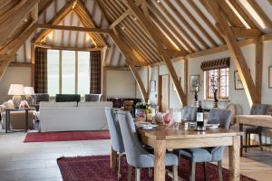 a living room with a wooden table and chairs at Lower Farm Barn in Hungerford