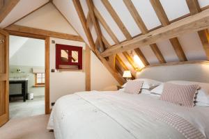 a bedroom with a large white bed in a attic at Lower Farm Barn in Hungerford