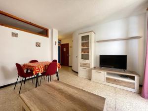 a living room with a table and a television at Edificio Playa in Los Cristianos