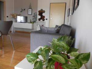 uma sala de estar com um sofá e um vaso de plantas em Hakuna Matata B&B em Pescara