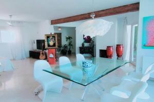 comedor con mesa de cristal y sillas blancas en Villa luxueuse avec vue mer en El Campello
