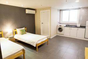 a room with two beds and a kitchen at Hostel Mihojae Busan in Busan