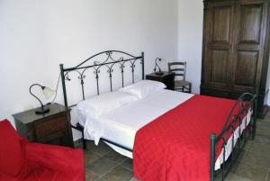 a bedroom with a large bed with a red blanket at Agriturismo La Lucia in Sant'Isidoro