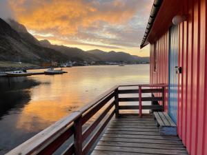 Kræmmervika Rorbuer - Rustic Cabins in Lofoten في بولستاد: منزل على مرسى مطل على الماء