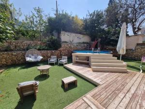 einen Hinterhof mit einem Pool und einer Terrasse mit einem Tisch und Stühlen in der Unterkunft shirly three bedroom house in Herzlia