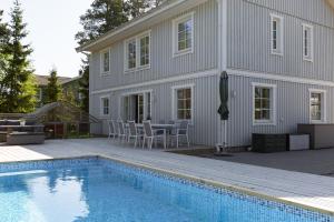 a house with a swimming pool in front of a house at Spacious accommodation near Stockholm with heated pool 