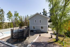una casa con un aro de baloncesto delante de ella en Spacious accommodation near Stockholm with heated pool, 