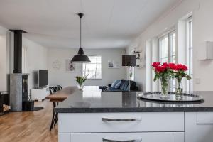 a kitchen and living room with red roses on a counter at Spacious accommodation near Stockholm with heated pool 