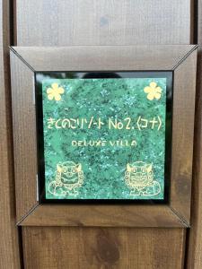a picture of a sign in a wooden box with aigraphy at きくのこ3缶ヴィラ＆テラス　 in Miyako Island