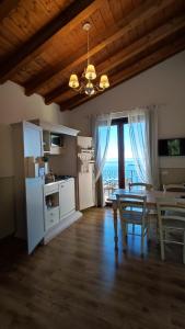 a living room with a table and a kitchen with a view at Agriturismo Il Casale Del Lago in Gardone Riviera