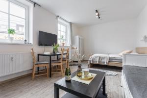 a white living room with a table and a couch at Vlevo dole Koko Apartment in Rokytnice nad Jizerou