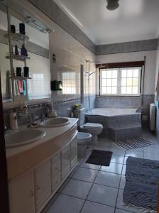 a bathroom with two sinks and a tub and a toilet at Casa do Espinheiro in São Mamede