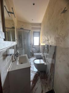 La salle de bains est pourvue de 2 lavabos, de toilettes et d'une douche. dans l'établissement B&B Narcisse, à Tropea