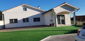 a white house with a green lawn at Casa do Espinheiro in São Mamede