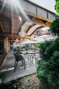 eine Außenterrasse mit Tischen, Stühlen und einem Kronleuchter in der Unterkunft Hotel Riesengebirge in Neuhof an der Zenn
