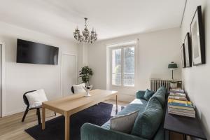 a living room with a blue couch and a table at La Savoy 2 - Thermes de Saint-Gervais - Happy Rentals in Saint-Gervais-les-Bains