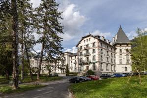 a large white building with cars parked in front of it at La Savoy 2 - Thermes de Saint-Gervais - Happy Rentals in Saint-Gervais-les-Bains