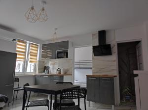 a kitchen with a table and chairs in a room at Nowe Apartamenty na Światowida VITO APARTMENTS "centrum"molo 5 min spacerem" in Międzyzdroje