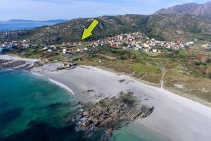 a yellow kite is flying over a beach at Apartamento Ancora Caldebarcos in San Mamede de Carnota