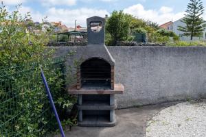 a brick oven sitting next to a wall at Apartamento Ancora Caldebarcos in San Mamede de Carnota
