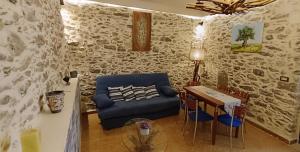 a living room with a blue couch and a table at VILLA PENELOPE in Tourlotí