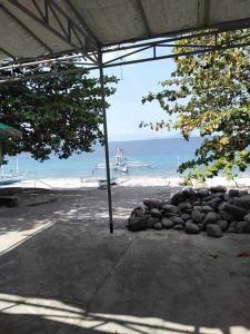 a pile of rocks on the beach with a boat at Room in Lobo Triple N Home stay 1st N in Lobo