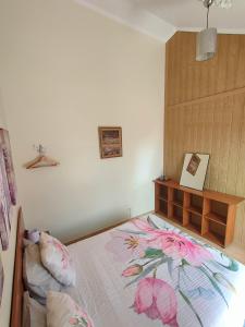 フンシャルにあるCosta Residence Funchal Viewのベッドルーム1室(花の毛布付きのベッド1台付)