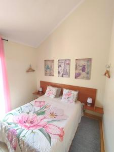 Un dormitorio con una cama con flores rosas. en Costa Residence Funchal View en Funchal