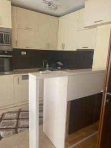 uma cozinha com armários brancos e um balcão branco em Viki Apartments em Strumica