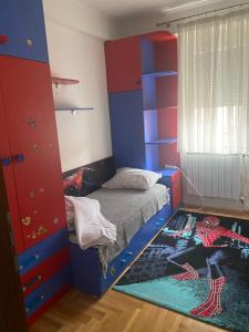 a bedroom with a blue and red bunk bed and a rug at Viki Apartments in Strumica