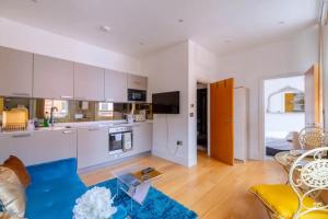 a kitchen and living room with white cabinets and a blue rug at Central & Cosy 1BD Flat - Soho in London