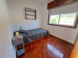 um quarto com uma cama e piso em madeira em Playa América, Nigrán, dúplex. em Nigrán