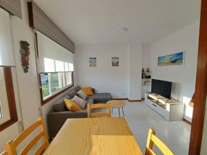 uma sala de estar com um sofá e uma mesa em Playa América, Nigrán, dúplex. em Nigrán