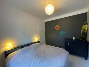 a bedroom with a white bed and a black wall at Villa Landaise Rénovée Proche Plages - Jardin et Terrasse Privatifs - FR-1-413-80 in Capbreton