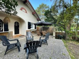 a patio with chairs and a table and an umbrella at Maison Capbreton, 3 pièces, 4 personnes - FR-1-413-80 in Capbreton