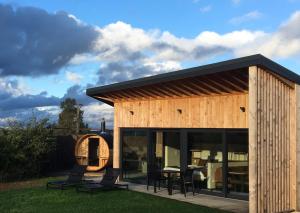 una casa in legno con due sedie in un cortile di Beau Réveil nature & wellness - gite 2 a Dochamps