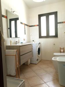 uma casa de banho com uma máquina de lavar roupa e uma máquina de lavar e secar roupa em Giovanni 's House em Budoni