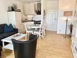 a kitchen and a living room with a table and chairs at Wohnpark Stadt Hamburg - Apt. 50 in Binz