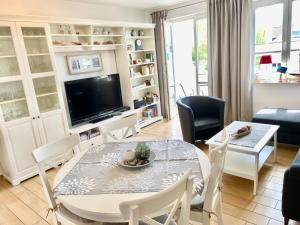 a living room with a table and chairs and a television at Wohnpark Stadt Hamburg - Apt. 50 in Binz