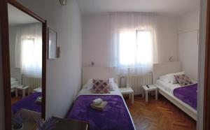 een kleine kamer met twee bedden en een spiegel bij Pansion restoran Marin in Posedarje