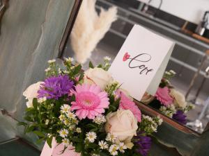 ein Blumenstrauß in einer Kiste mit einem Schild in der Unterkunft La loveroom de l'Artois in Souchez
