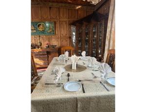 une table avec des assiettes et des serviettes en haut dans l'établissement House Boat Shahnama, Dal Lake, à Kārapur