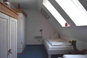 プレローにあるKormoran Muschelsucherのベッドと窓が備わる屋根裏部屋