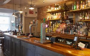 a bar with a lot of bottles of alcohol at Trents by Greene King Inns in Chichester