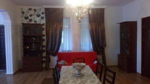 a dining room with a table and a red couch at DONNA in Tsinsopʼeli