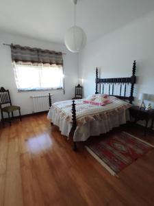 una camera con letto e pavimento in legno di Casa do Espinheiro a São Mamede