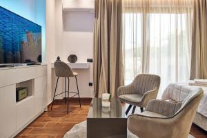 uma sala de estar com duas cadeiras e uma televisão em Amuse Luxury Apartments em Zakynthos Town
