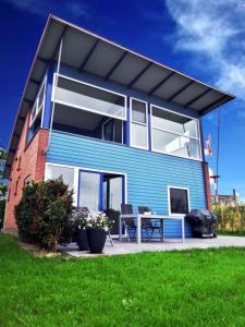 a blue house with a table in front of it at Ferienhaus Jasmijn mit Garten und Terrasse in Anjum