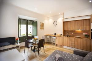 a kitchen and living room with a table and chairs at Apartament al cor del barri vell de Girona in Girona