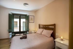 - une chambre avec un lit et une serviette dans l'établissement Apartament al cor del barri vell de Girona, à Gérone